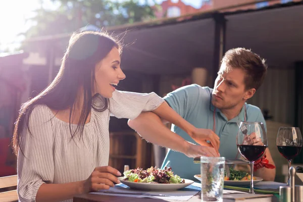 Жадный мужчина не позволяет своей женщине попробовать его салат — стоковое фото