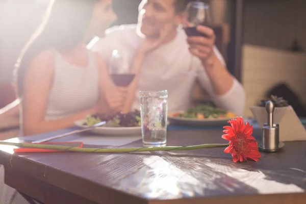 Krásný červený květ ležící na dřevěný stůl — Stock fotografie