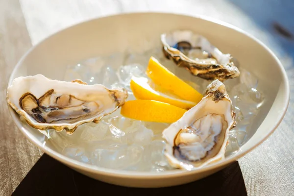 Üç küçük taze istiridye plaka limon yakınındaki yalan