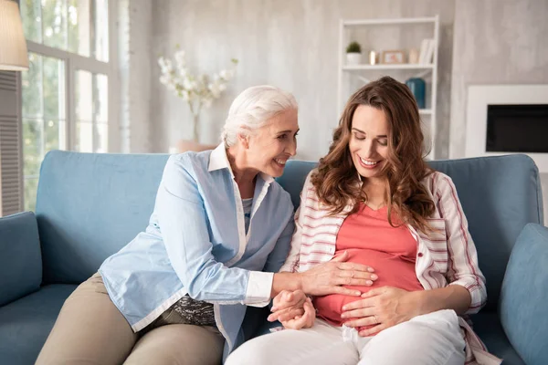 Kind-hearted mother coming for visiting her pregnant daughter — Stock Photo, Image