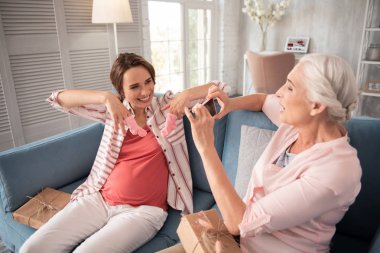Açma esmer hamile kadın küçük kız bebek için sunar