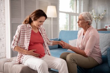 Gri saçlı anne hamile kızı destekleyen