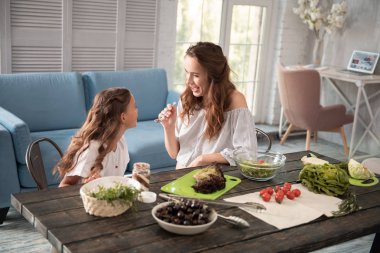 Koyu renk saçlı anne onun kızı çikolata yayıldı veren bakım