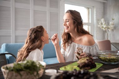 Sevimli kızı beslerken gülüyor kadın gülen