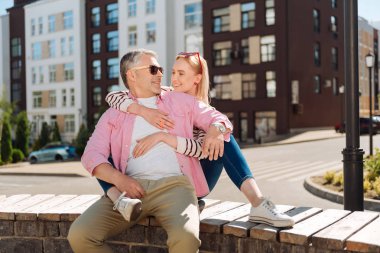 Bankta oturan olumlu neşeli çift