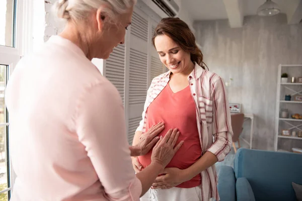 Nadšený, matka položila ruce na těhotné bříško — Stock fotografie