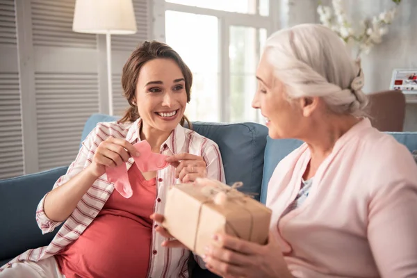 Mörkögda havande kvinna känner sig förvånad som fick lite presenterar — Stockfoto