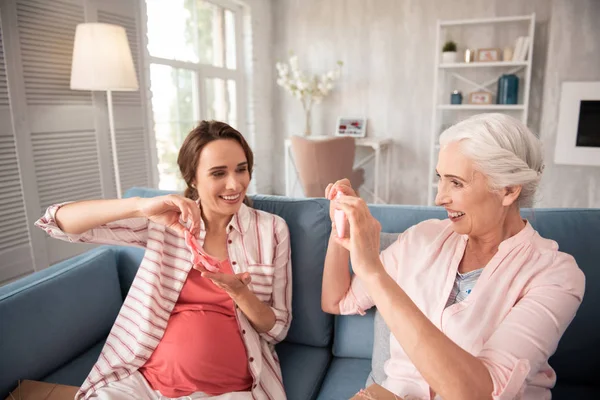 Smiling caring aged mother making photo of expecting daughter — Stock Photo, Image