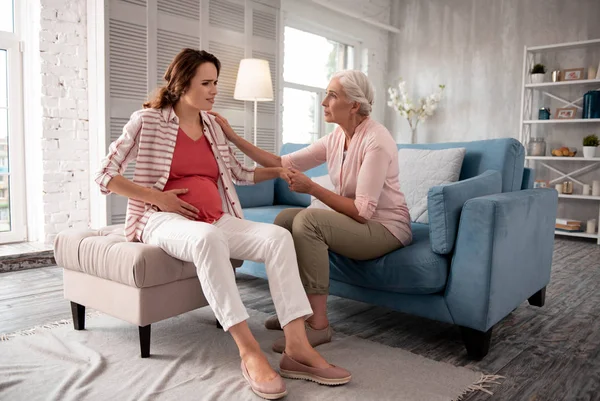 Caring mother coming to her expecting daughter feeling dizzy — Stock Photo, Image