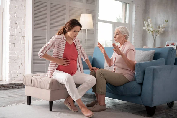 Caring mother calming her pregnant daughter having ache — Stock Photo, Image