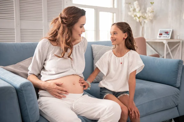 Kleine süße Tochter kommt zu ihrer schwangeren Mutter — Stockfoto