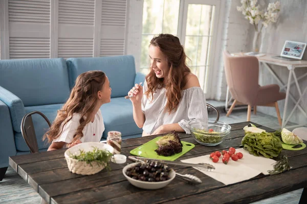 Koyu renk saçlı anne onun kızı çikolata yayıldı veren bakım