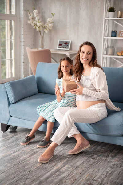 Feliz mujer embarazada recibiendo regalo de la hija cariñosa — Foto de Stock