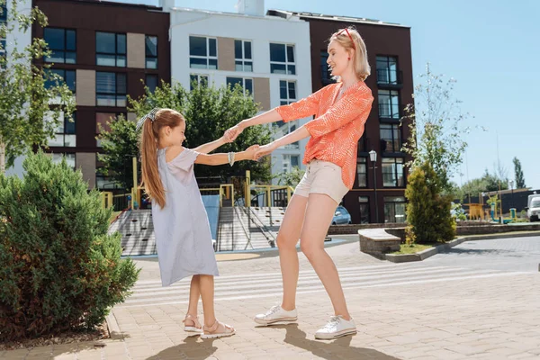 Kızları ellerini tutan memnun genç kadın