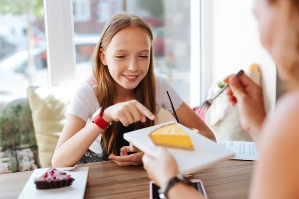 Sonriente adolescente probando cheesecake con su madre —  Fotos de Stock