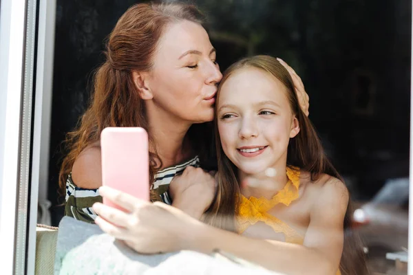 Любящая красивая мать целует свою любящую дочь — стоковое фото