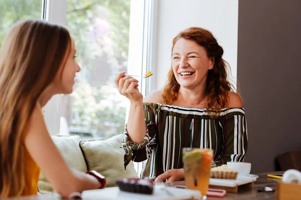 Roodharige vrouw lachen terwijl het spreken aan dochter — Stockfoto