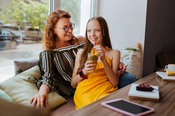 Stralende blonde-haired meisje haar freelance moeder meedoen café — Stockfoto