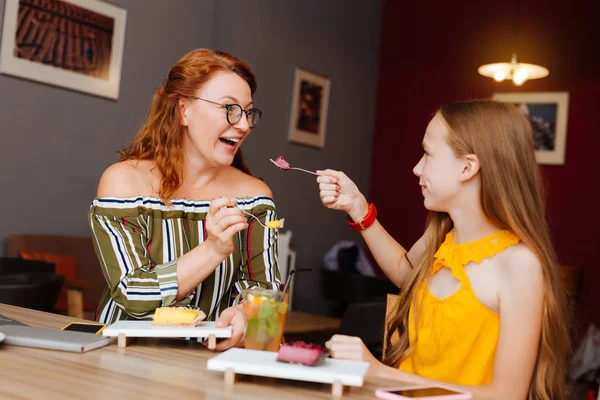 Red-haired smiling mother enjoying sweet desserts with daughter — Stock Photo, Image