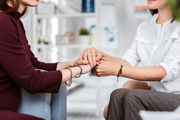 Zwei Frauen, die sich an den Händen halten und freundlich aussehen — Stockfoto