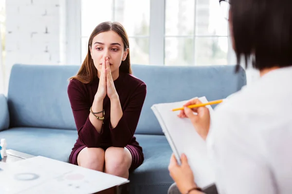 Paciente preocupada tocando su cara mientras habla — Foto de Stock