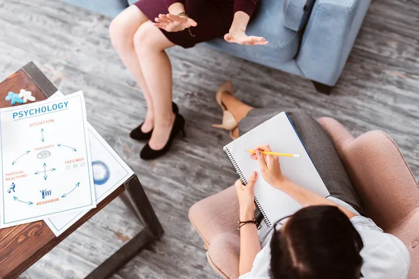 Paciente emocional usando gestos y un psicólogo haciendo notas — Foto de Stock