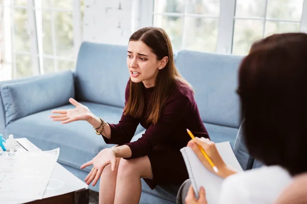 Expressieve patiënt met behulp van gebaren en praat tegen haar psycholoog — Stockfoto