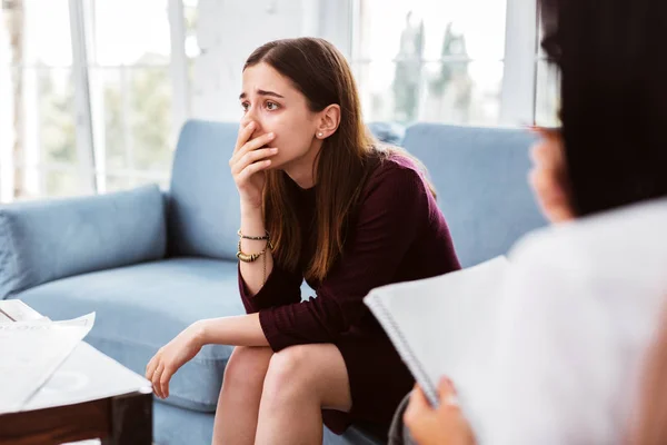 Treurige vrouw haar gezicht aan te raken en begrijpen haar miserabele situatie — Stockfoto