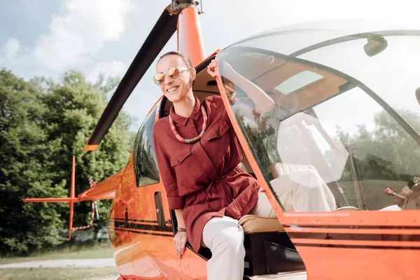 Adorable mujer alegre bajándose del helicóptero — Foto de Stock