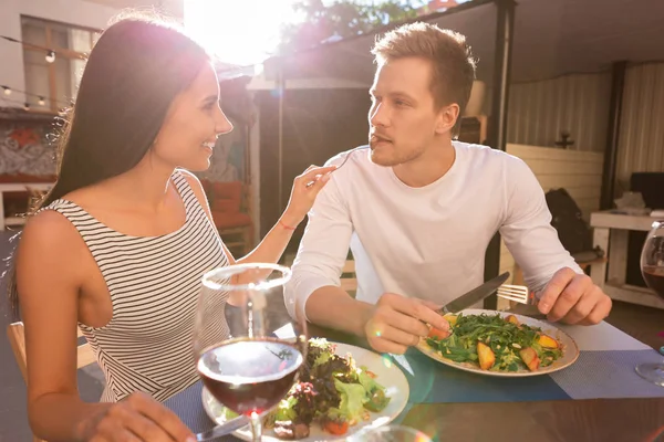 Snygga blonda man äta kött med sin flickvän — Stockfoto