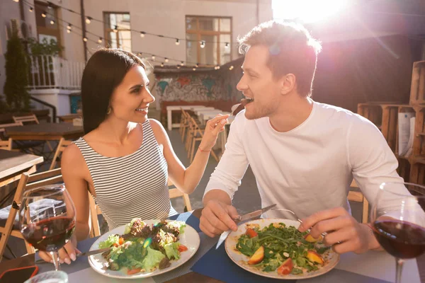 Привлекательная женщина в стильной одежде кормит своего любящего мужчину — стоковое фото