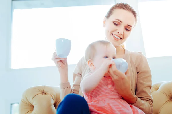 Positivo felice bionda che alimenta sua figlia — Foto Stock