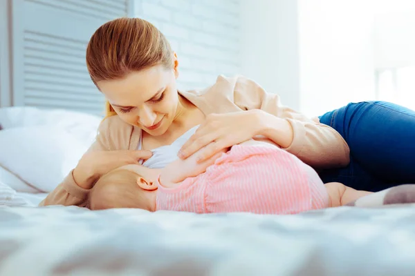 Attentive female person nursing her baby — Stock Photo, Image