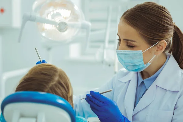 Bevoegde tandarts behandeling van haar bezoeker — Stockfoto