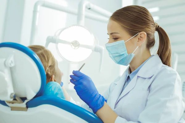 Веселый стоматолог осматривает больные зубы — стоковое фото