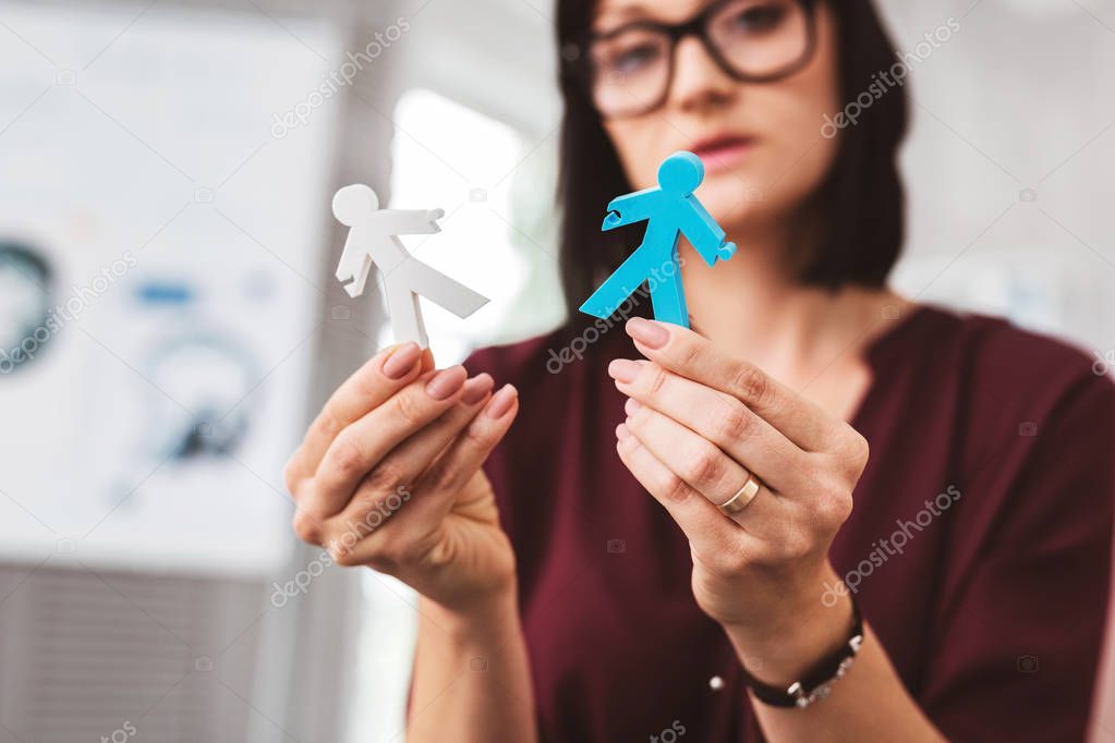 Sad woman thinking about a broken family while holding stickmen