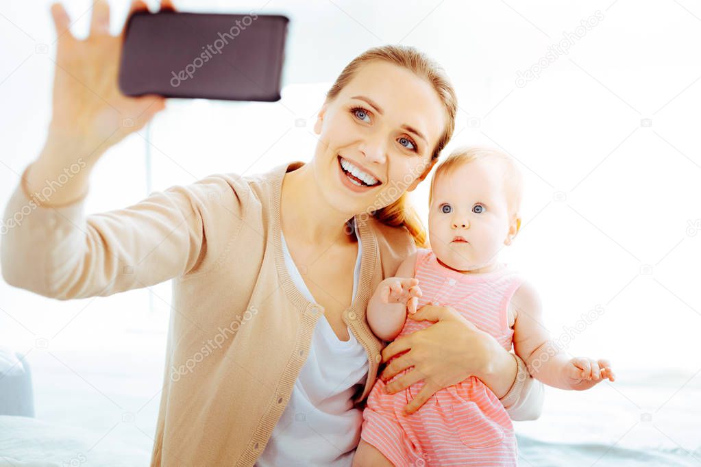 Happy young mother doing photo