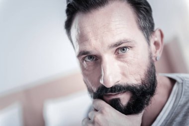 Düşünceli sakallı erkek kişi size bakarken