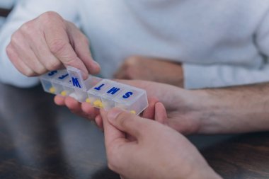 Yaşlı adam sarı bir vitamini alarak