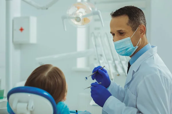 Aantrekkelijke mannelijke persoon werken bij tandarts chirurgie — Stockfoto
