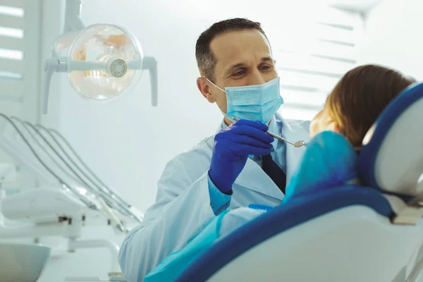 Aantrekkelijke tandarts behandeling van zijn patiënt — Stockfoto