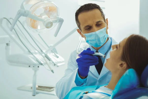 Dentista competente lutando com cárie — Fotografia de Stock