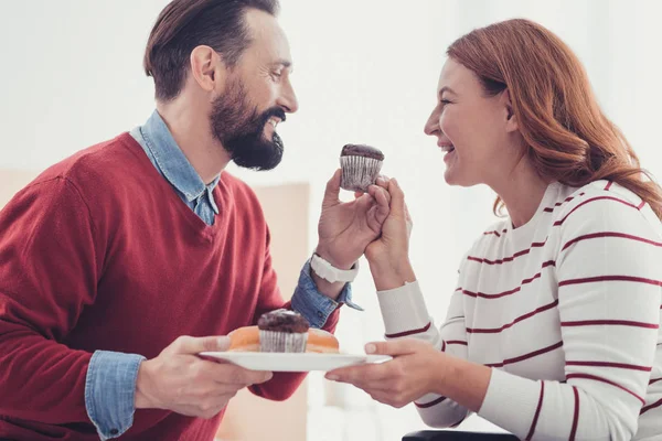 Emocionální pár usmívající se přitom jíst chutné dorty dohromady — Stock fotografie