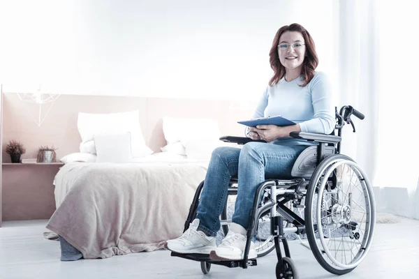 Mulher agradável sentada em sua cadeira de rodas — Fotografia de Stock