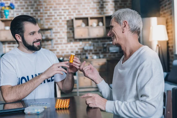 Hombre sonriente ofreciendo un nuevo medicamento — Foto de Stock