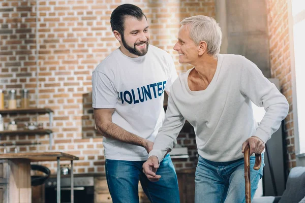 Добрый радостный человек помогает пожилому человеку — стоковое фото