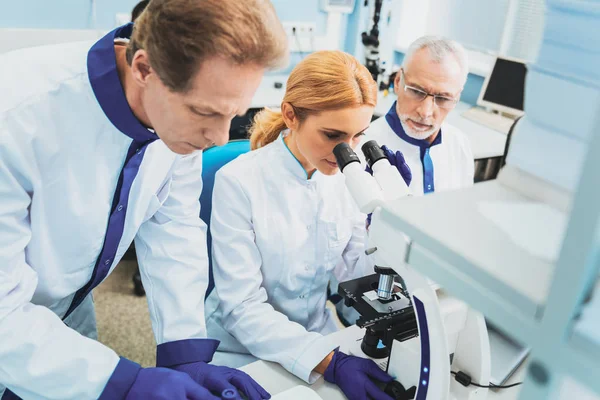 Group of attentive researchers working at experiment — Stock Photo, Image