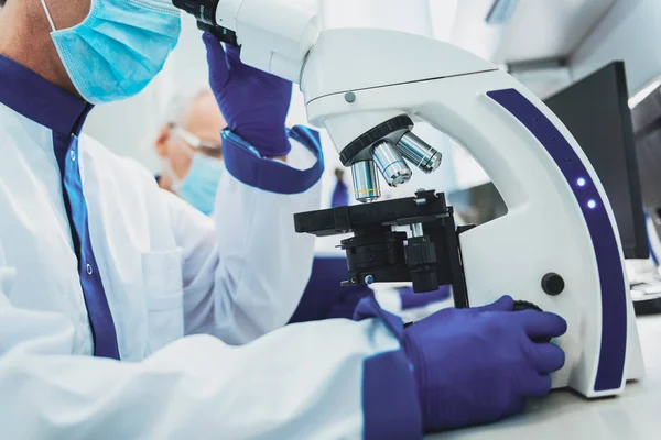 Close up of male hand that touching microscope — Stock Photo, Image