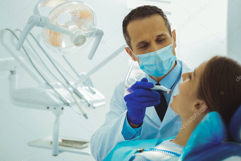 Competent dentist fighting with caries