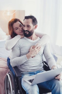 Adam bir dizüstü bilgisayar ve eşi onu sarılma tutma engeli